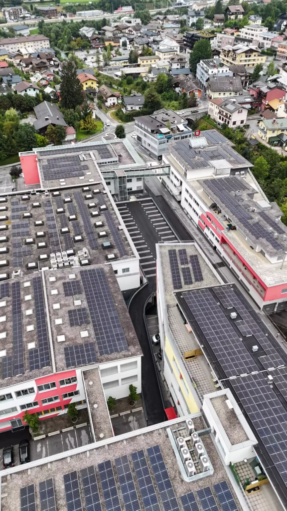 default Luftaufnahme eines modernen Gewerbegebiets mit mehreren Gebäuden und zahlreichen Solarpanelen auf den Dächern, umgeben von