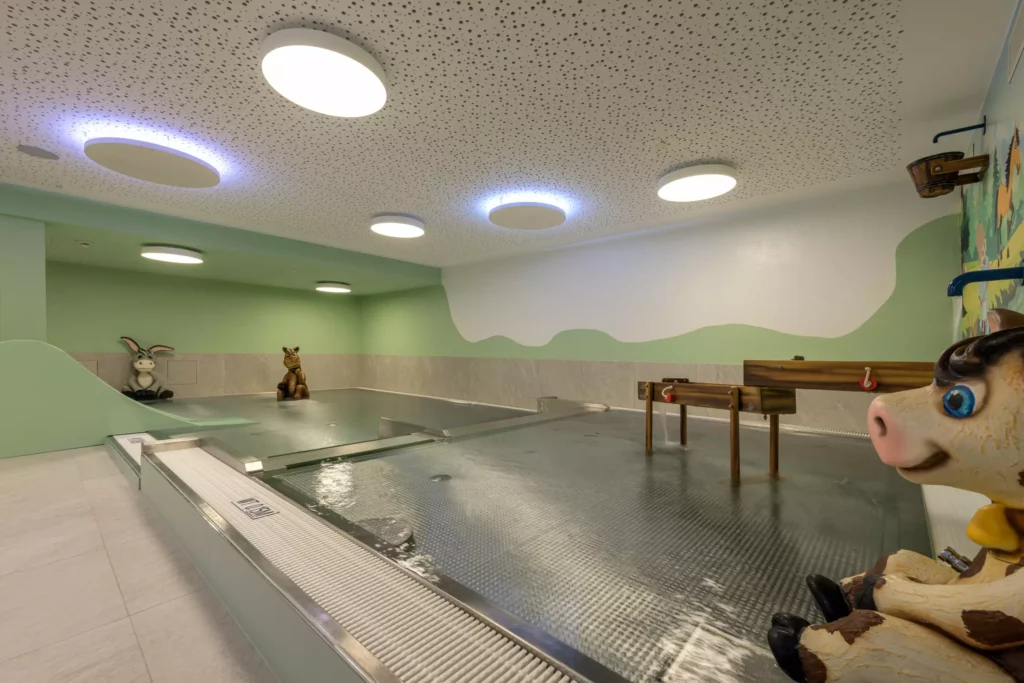2024-06-13_Deutinger-Hotel-Kesselgrub-©sobietzki-high-res-10 Innenansicht eines Kinderhallenbads mit Tierfiguren und moderner Beleuchtung im Hotel Kesselgrub, Projektentwicklung Hochbau