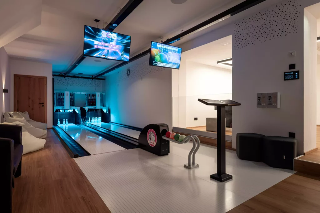 2024-06-13_Deutinger-Hotel-Kesselgrub-©sobietzki-high-res-14 Moderne Indoor-Kegelbahn mit zwei Bahnen, Sitzsäcken, Monitoren zur Spielanzeige und Holzfußboden im Deutinger Hotel