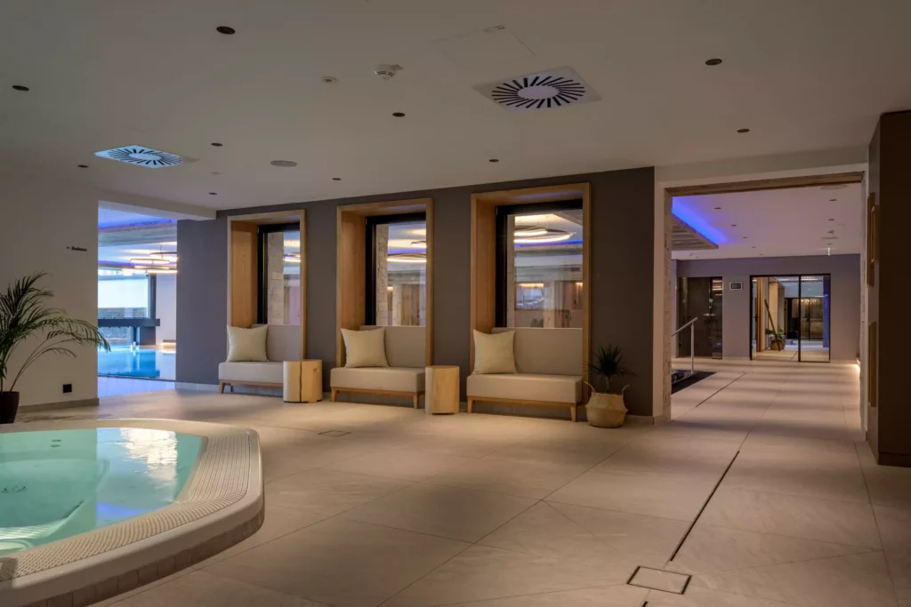 2024-06-13_Deutinger-Hotel-Kesselgrub-©sobietzki-high-res-6 Moderner Wellnessbereich mit Whirlpool, Sitzbänken und Blick auf einen Pool im Hotel Kesselgrub, Deutinger Projektentwicklung