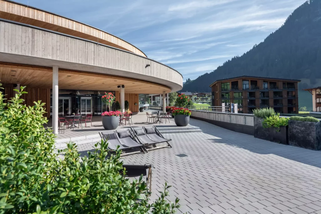 2024-08-19_Talstation-Kieserl-Grossarl-©sobietzki-low-res-2560px-16 Moderne Talstation mit Sitzbereich, Liegestühlen und großen Blumentöpfen vor Bergkulisse in Großarl im Sommer
