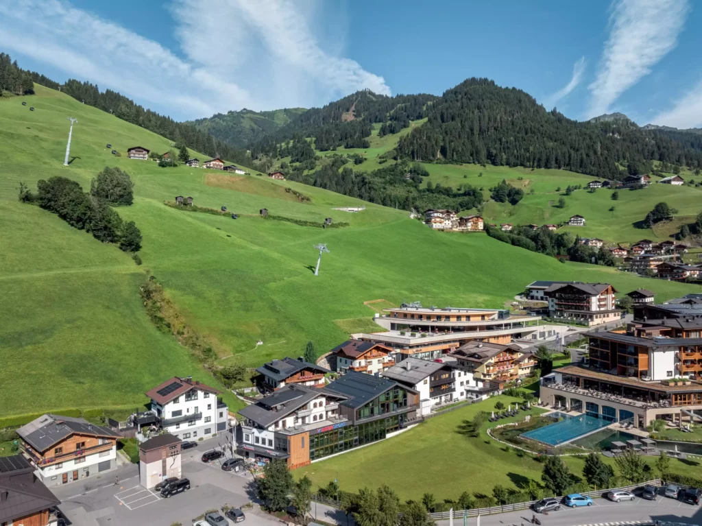 2024-08-19_Talstation-Kieserl-Grossarl-©sobietzki-low-res-2560px-3 Talstation Kieserl in Großarl mit moderner Bergbahn, grünen Almwiesen und umliegenden Gebäuden im Sommer unter blauem Himmel