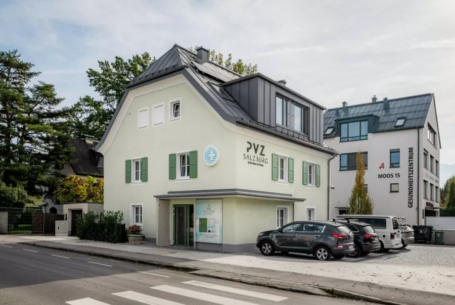 Modernisiertes Gebäude mit PVZ Salzburg Praxis und angrenzendem Gesundheitszentrum in Salzburg, Parkplätze davor, ruhige