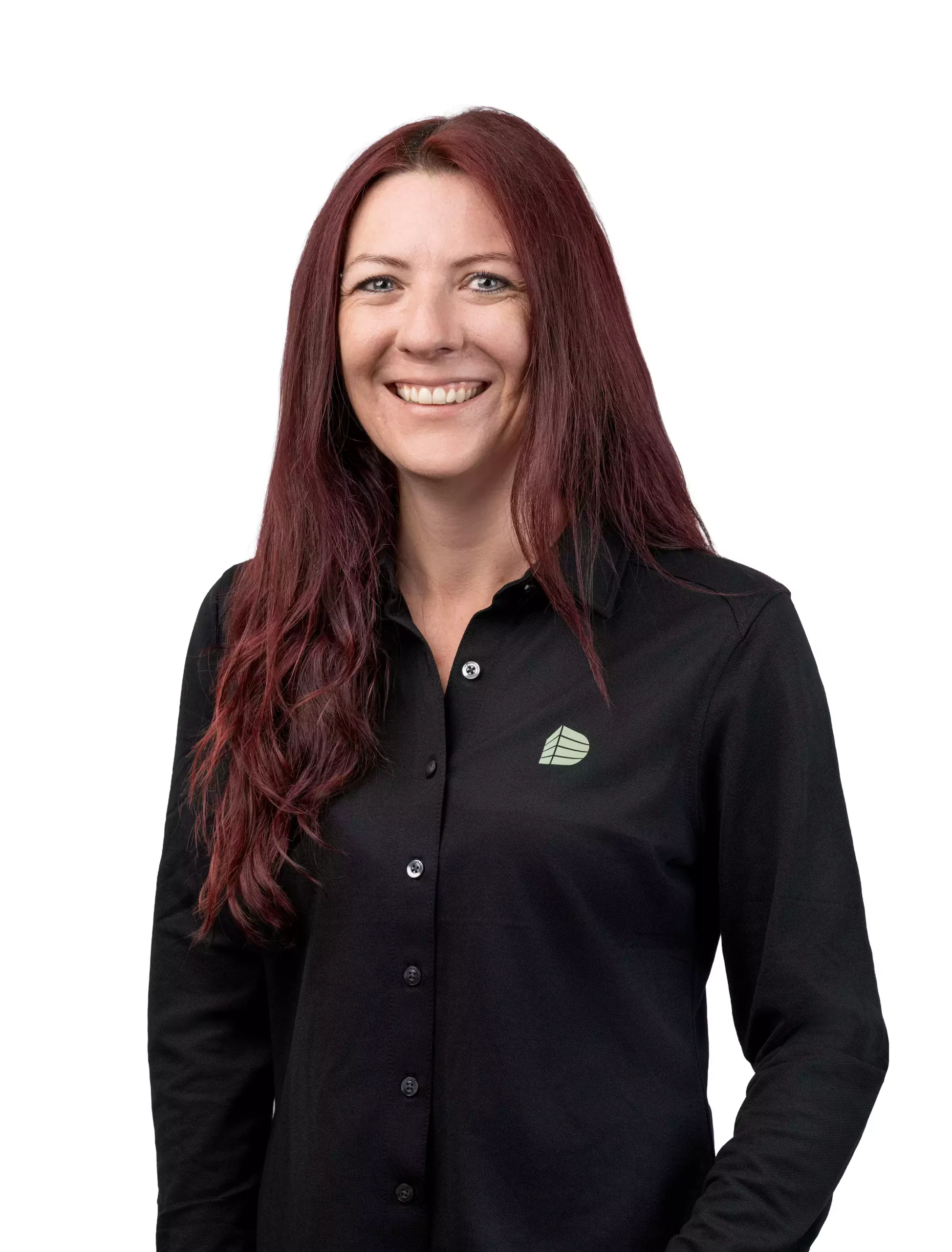 Porträt einer lächelnden Frau mit langen roten Haaren in schwarzem Hemd mit Firmenlogo vor weißem Hintergrund