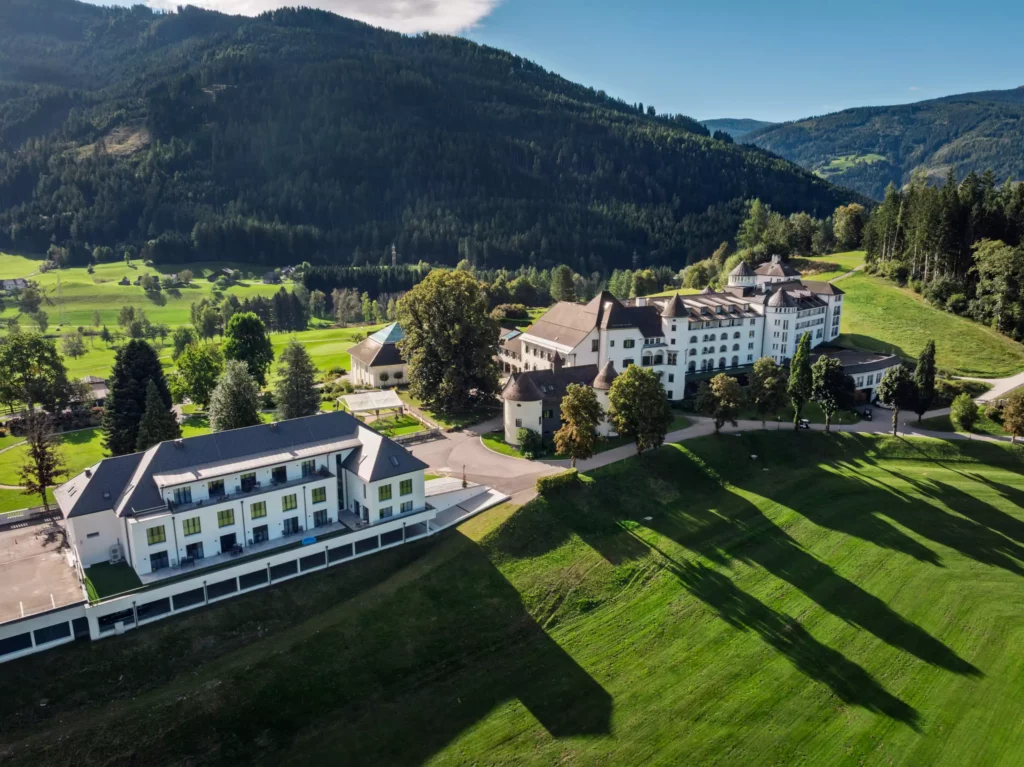251016_Deutinger-Mitarbeiterhaus-Pichlarn-©sobietzki-low-res-2560px-16 Modernes Mitarbeiterhaus und historisches Schlossgebäude in grüner Berglandschaft bei Pichlarn im Sonnenlicht