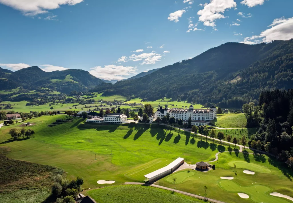 251016_Deutinger-Mitarbeiterhaus-Pichlarn-©sobietzki-low-res-2560px-21 Mitarbeiterhaus Deutinger in Pichlarn eingebettet in grüne Landschaft mit Golfplatz und Bergen im Hintergrund bei