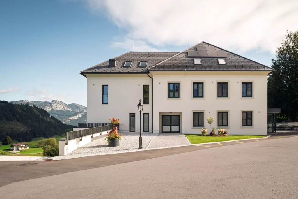 251016_Deutinger-Mitarbeiterhaus-Pichlarn-©sobietzki-low-res-2560px-3 Modernes zweistöckiges Mitarbeiterhaus mit Solarpanelen auf dem Dach, umgeben von Bergen und grüner Landschaft in Pichlarn