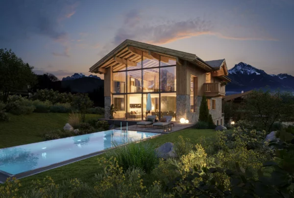 Modernes Chalet mit großflächigen Glasfronten, beleuchtetem Pool und Bergpanorama bei Abenddämmerung