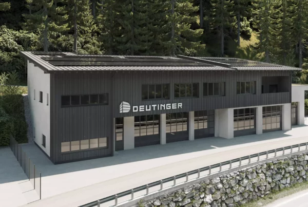 Modernes Gewerbegebäude mit schwarzer Fassade und großem Deutinger-Logo im Gewerbepark Großarl vor Waldkulisse