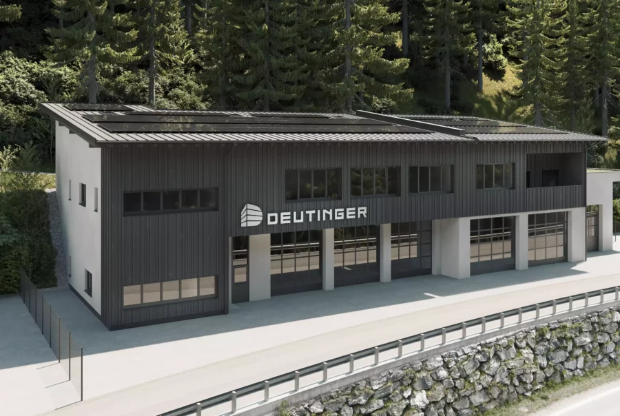 Modernes Gewerbegebäude mit schwarzer Fassade und großem Deutinger-Logo im Gewerbepark Großarl vor Waldkulisse