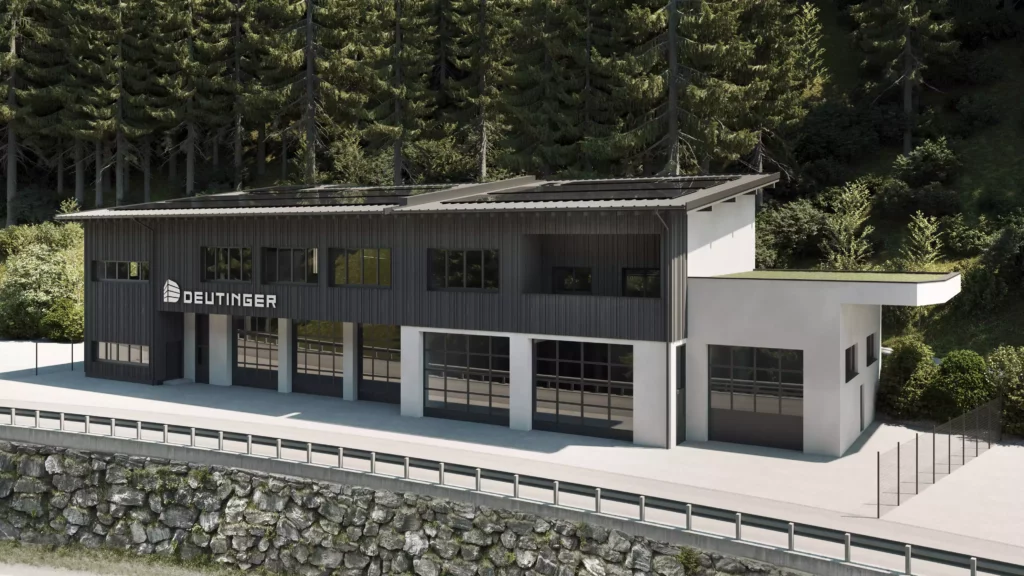 Gewerbepark_Grossarl_2 Modernes Gewerbegebäude mit schwarzer Fassade und großen Glasgaragentoren vor Waldkulisse im Gewerbepark Großarl
