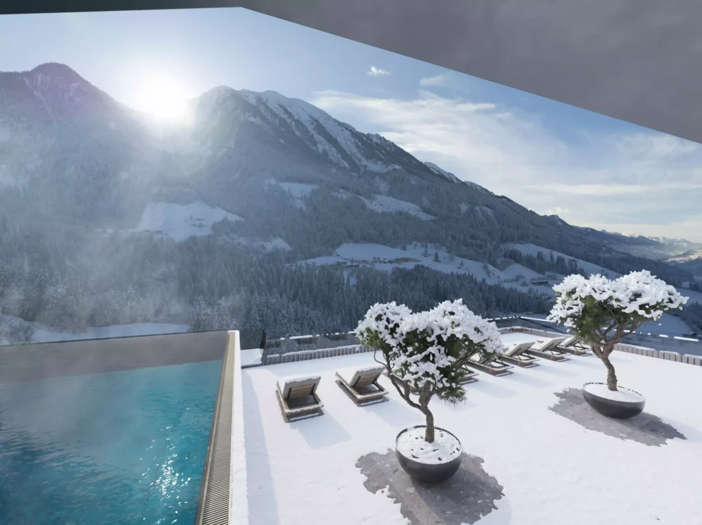 Hotel Berghof_01 Winterliche Dachterrasse mit beheiztem Pool, Liegestühlen und schneebedeckten Bäumen vor Bergpanorama im Hotel Berghof