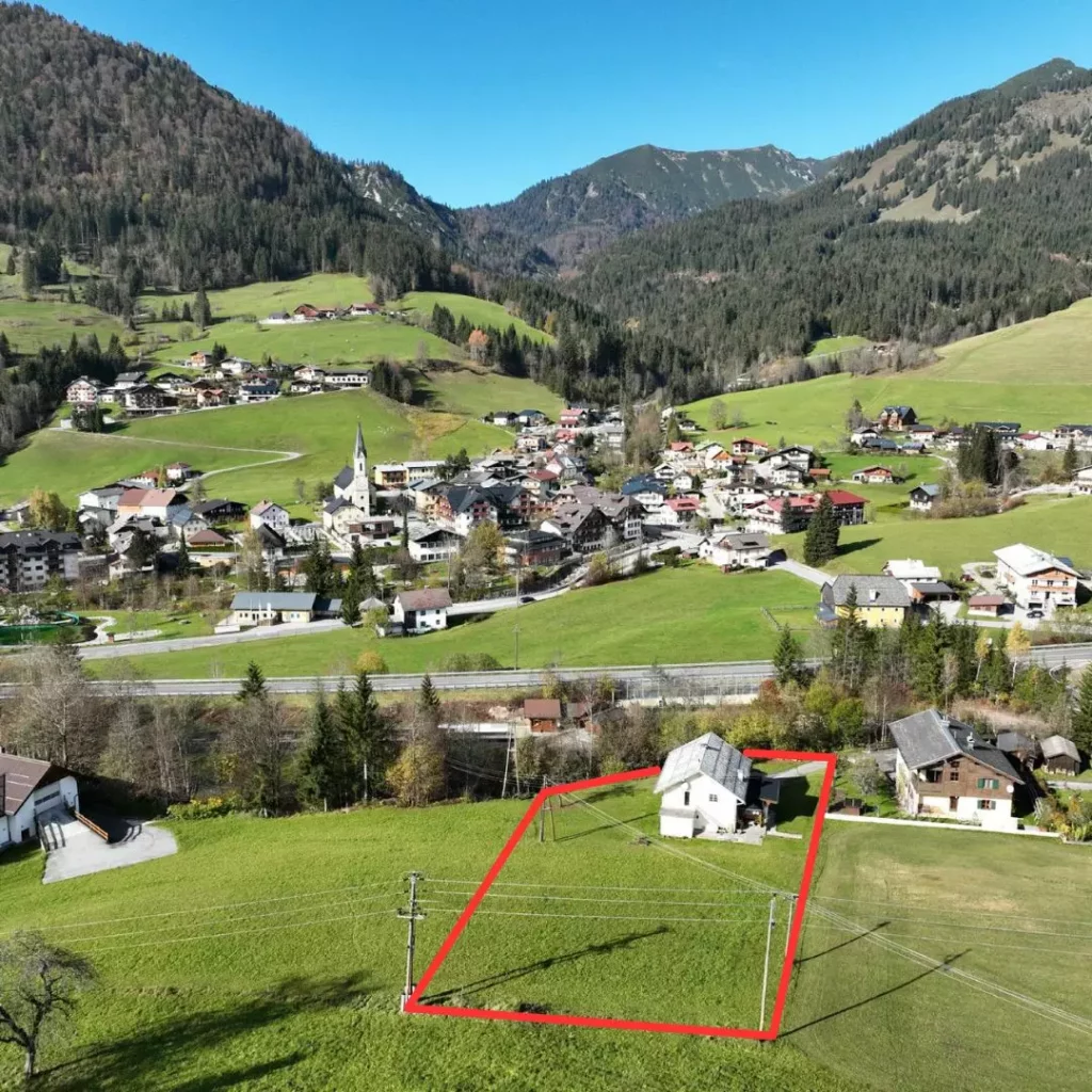 xr:d:DAGAIFpBtwQ:15,j:8357978696562805280,t:24040307 Luftaufnahme eines Hauses mit roter Grundstücksmarkierung in grüner Berglandschaft nahe Dorf Russbach mit Bergen im