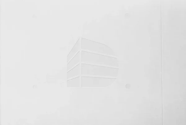Weißer Betonwand mit eingraviertem stilisiertem Gebäude-Logo, minimalistisch und modern gestaltet, deutinger platzhalter