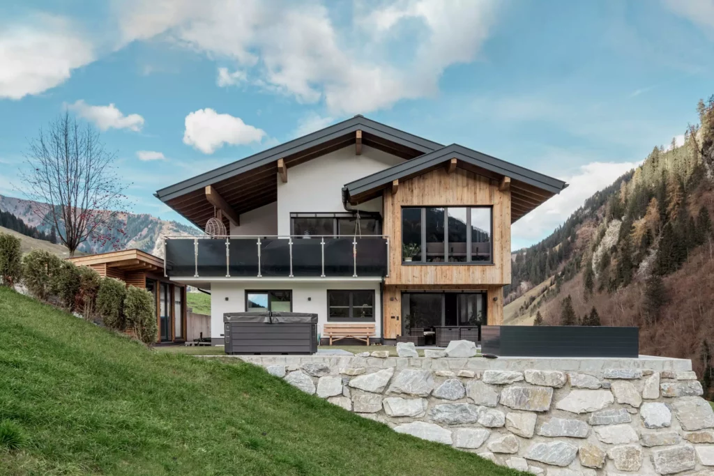 deutinger-projektentwicklung-baumanagement-generalunternehmen-immobilien-salzburg-MFH-Grossarl-Gfrerer-Schwarb-2 Modernes Mehrfamilienhaus mit Holzfassade und Balkon in bergiger Landschaft bei Großarl, Salzburg, Bauprojektmanagement und