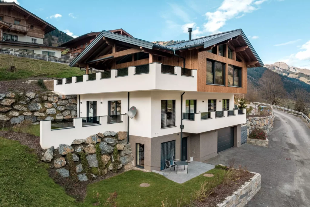 deutinger-projektentwicklung-baumanagement-generalunternehmen-immobilien-salzburg-MFH-Grossarl-Wagnermeyer-6 Modernes Mehrfamilienhaus mit Holzfassade und großer Terrasse in bergiger Landschaft bei Großarl, Salzburg