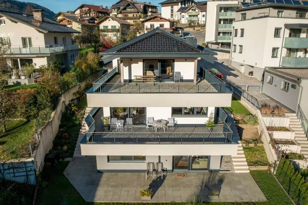 deutinger-projektentwicklung-baumanagement-generalunternehmen-immobilien-salzburg-Mehrfamilienhaus-Altenberger-6 Modernes Mehrfamilienhaus mit großen Balkonen und Terrasse in sonniger Wohnlage, umgeben von weiteren Wohngebäuden
