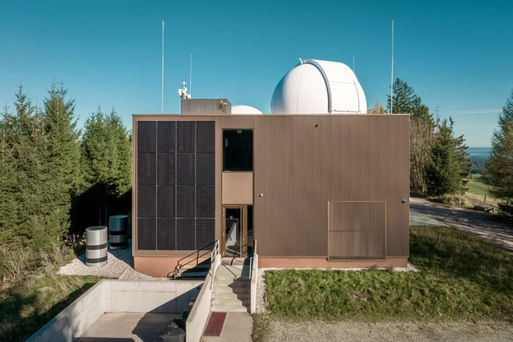 deutinger-projektentwicklung-baumanagement-generalunternehmen-immobilien-salzburg-Sternwarte-Haus-der-Natur-10 Modernes Bauprojekt mit Solarpaneelen und Sternwartekuppel in ländlicher Umgebung bei Salzburg