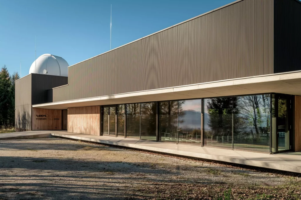 deutinger-projektentwicklung-baumanagement-generalunternehmen-immobilien-salzburg-Sternwarte-Haus-der-Natur-4 Modernes Gebäude der Sternwarte Haus der Natur in Salzburg mit großer Glasfront und Kuppel unter blauem Himmel