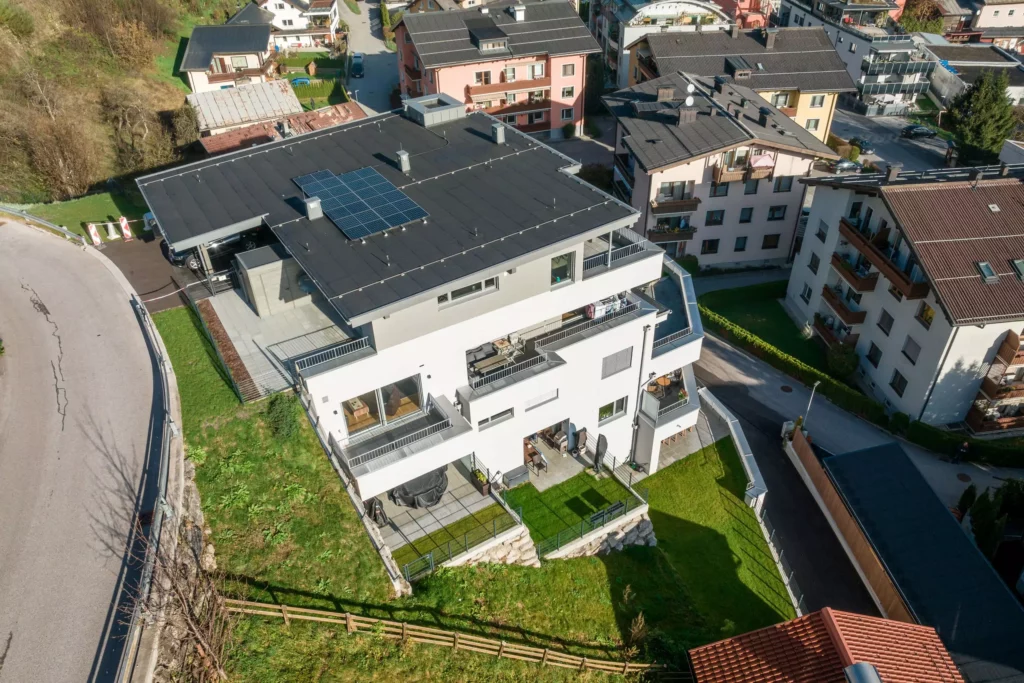 deutinger-projektentwicklung-baumanagement-generalunternehmen-immobilien-salzburg-Wohnpark-Bischofshofen-12 Moderner Wohnpark mit Balkonen und Solarpanelen auf dem Flachdach in Bischofshofen, Salzburg, umgeben von weiteren
