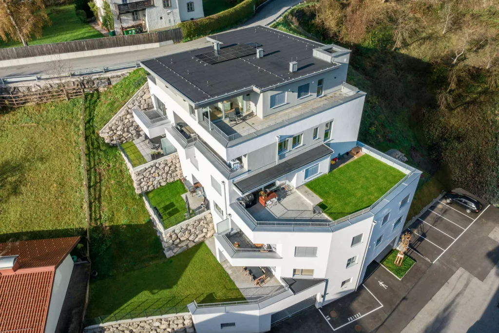 deutinger-projektentwicklung-baumanagement-generalunternehmen-immobilien-salzburg-Wohnpark-Bischofshofen-7 Moderner mehrstöckiger Wohnkomplex mit großen Terrassen und begrünten Dachflächen in Bischofshofen, Salzburg, umgeben von