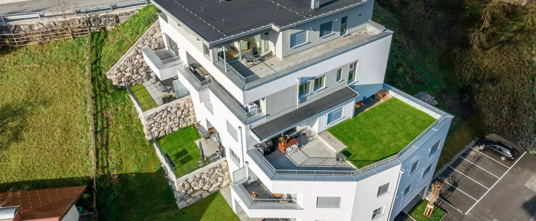 Moderner mehrstöckiger Wohnkomplex mit großen Terrassen und begrünten Dachflächen in Bischofshofen, Salzburg, umgeben von