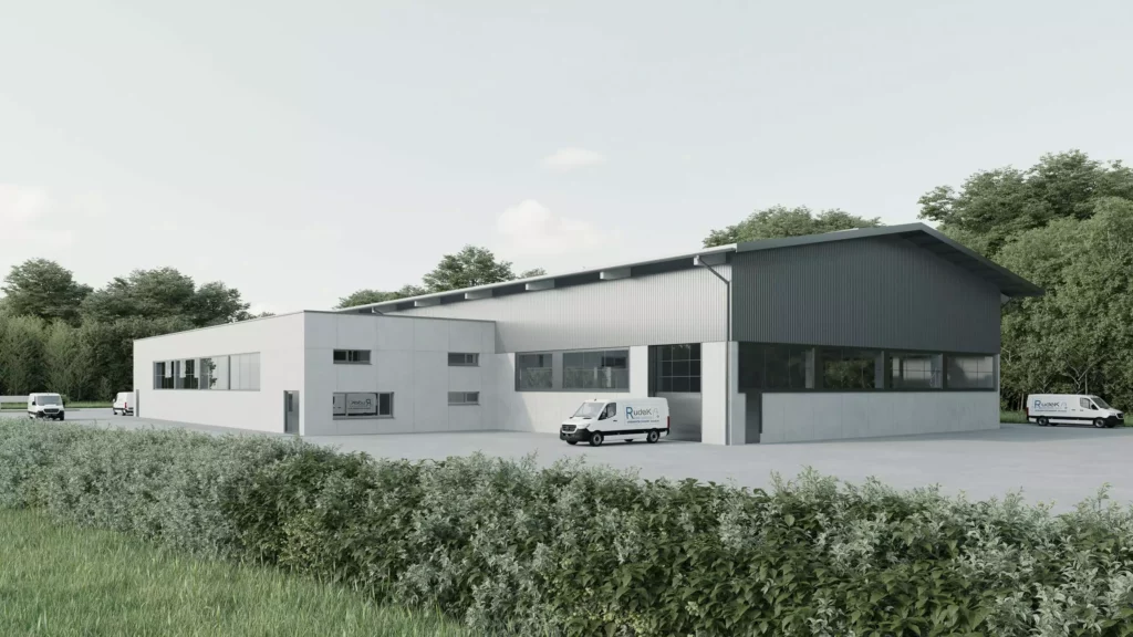 deutinger-projektentwicklung-baumanagement-generalunternehmen-immobilien-salzburg-projekt-betriebshalle-rudek-02 Moderne Betriebshalle mit Büroanbau und drei weißen Lieferwagen auf großem Parkplatz, umgeben von Bäumen und Grünflächen