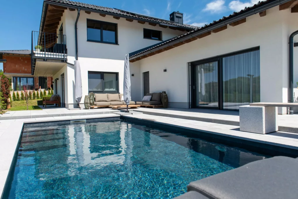 deutinger-projektentwicklung-baumanagement-generalunternehmen-immobilien-salzburg-projekt-einfamilienhaus-32 Modernes Einfamilienhaus mit Terrasse, Pool und Garten in Salzburg bei sonnigem Wetter, Projektentwicklung und Baumanagement