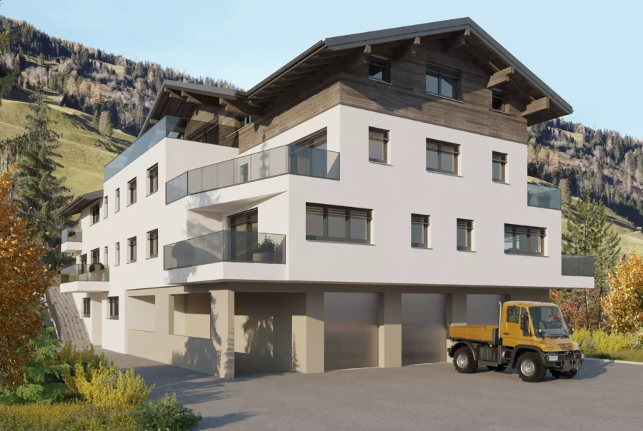 Modernes Mehrzweckhaus mit weißen Fassaden, Holzgiebel und Glasbalkonen vor Bergkulisse in Hüttschlag, Salzburg.