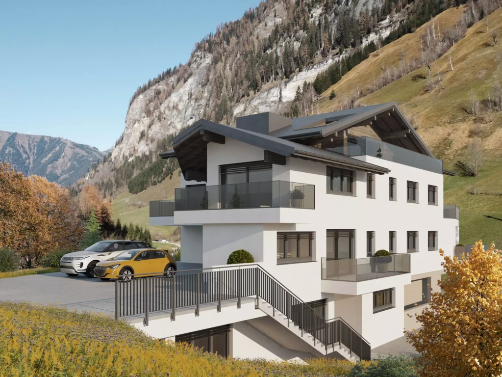 deutinger-projektentwicklung-baumanagement-generalunternehmen-immobilien-salzburg-projekt-mehrzweckhaus-huettschlag-03 Modernes Mehrzweckhaus mit Balkonen und Parkplätzen vor Bergkulisse im Herbst in Hüttschlag, Salzburg.