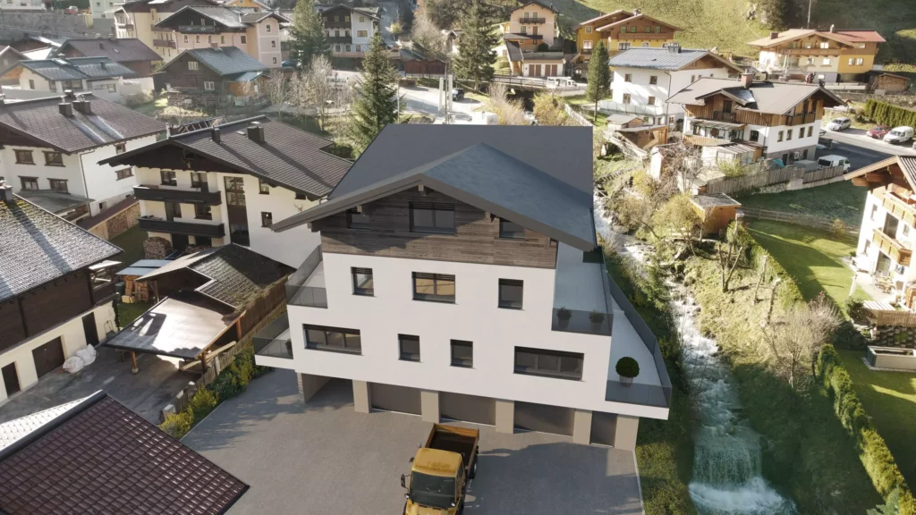 deutinger-projektentwicklung-baumanagement-generalunternehmen-immobilien-salzburg-projekt-mehrzweckhaus-huettschlag-04 Modernes Mehrzweckhaus mit Holzfassade und Balkonen in einem Dorf mit umliegenden Wohnhäusern und Bachlauf in Hüttschlag