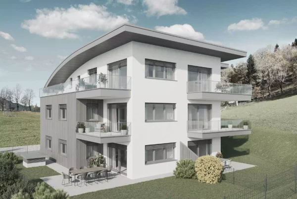 Modernes Wohngebäude mit Balkonen und Terrasse in grüner Hanglage unter blauem Himmel in Salzburg Alpendorf Mountainview