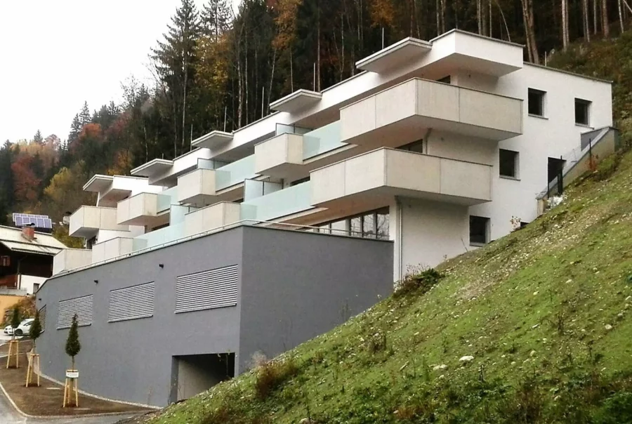 Modernes Wohngebäude mit Balkonen am Hang vor Wald in Salzburg Stegfeld, Projektentwicklung und Baumanagement